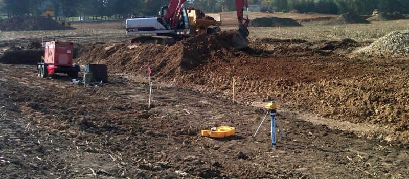 Excavation and Grading (9) photo of backhoe excavating dirt into a pile